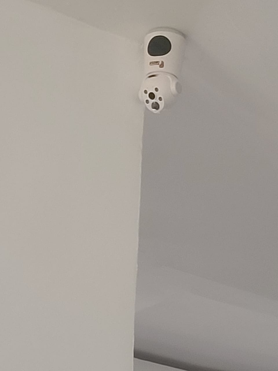 Indoor security camera mounted near a ceiling during IT POWERS installation work